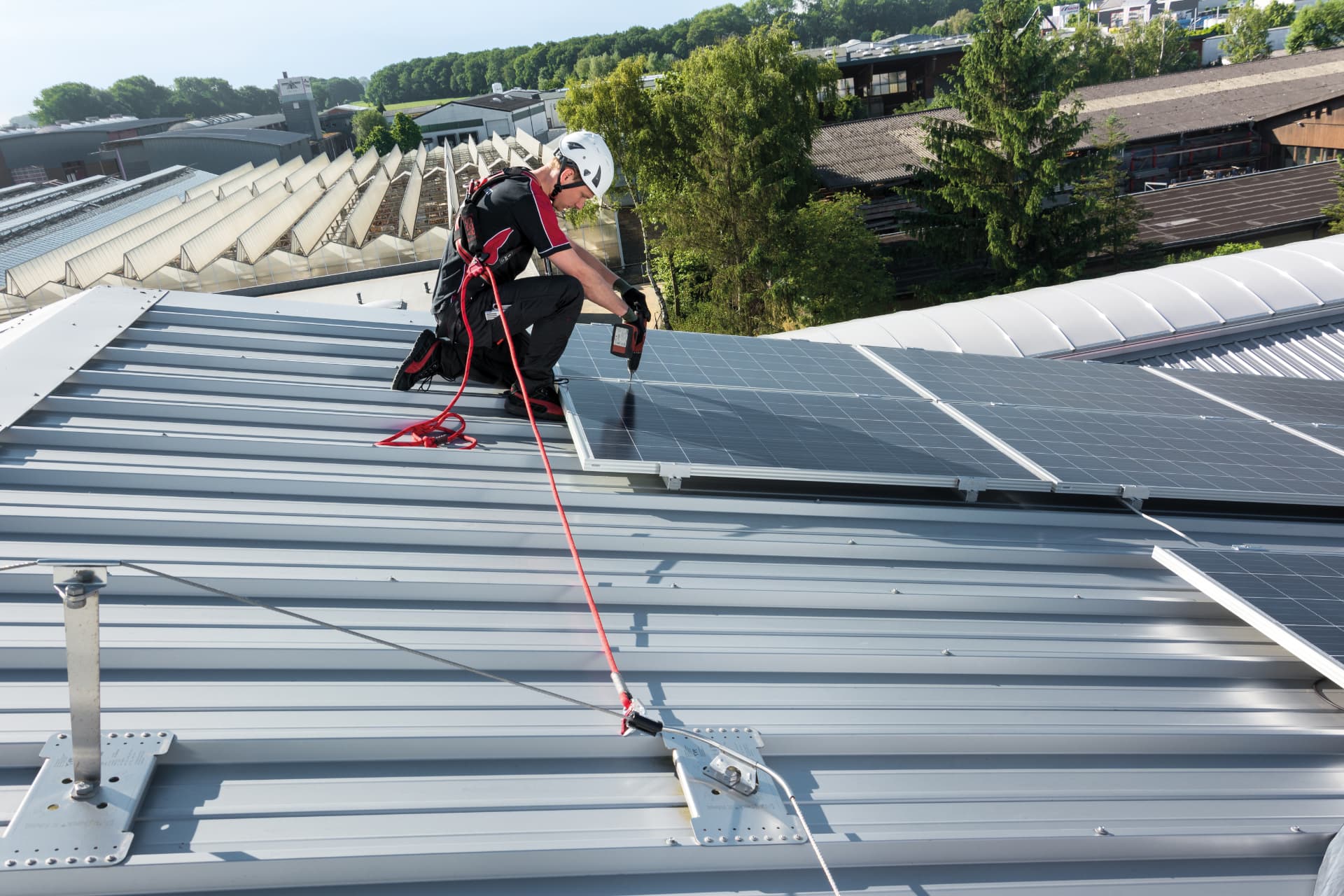 Monteur an einem Seilsystem angeschlagen bei Arbeiten an Photovoltaikmodulen